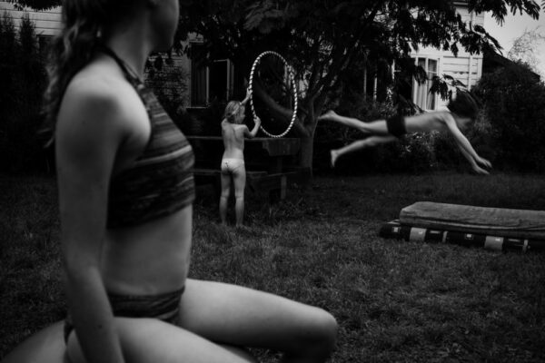 A group of people playing with hula hoops in the grass.