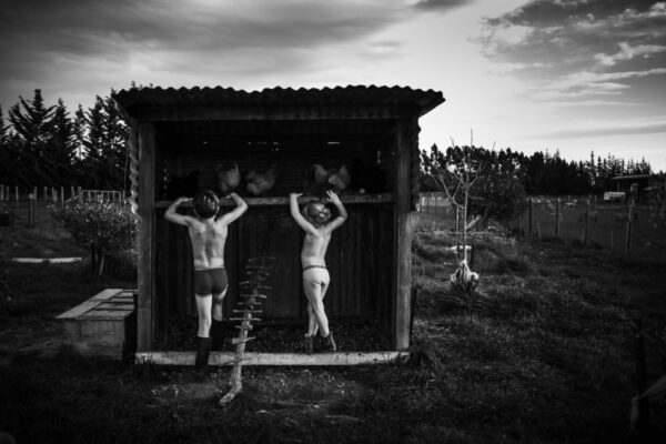 Two men hanging from a wooden structure in the middle of nowhere.
