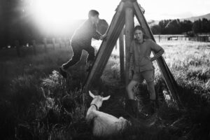 Two men and a sheep in the grass.