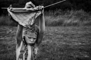 A young girl holding onto a bow and arrow.
