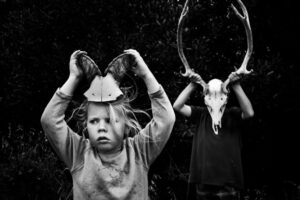 A young girl and man with animal heads on their head.