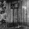 A black and white photo of an old barn.