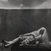 A woman in a dress and veil laying on the ground.