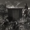 A woman standing in the grass with her belly.