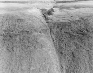 A black and white photo of the bottom of a cliff.