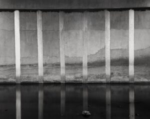 A black and white photo of water in front of a wall.