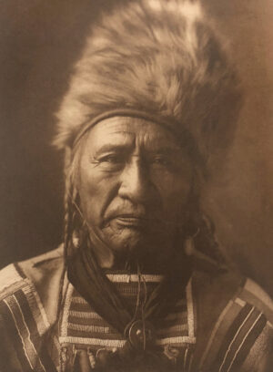 A man in native american garb with a feather hat.