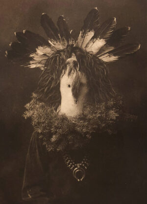A man in native american garb with feathers on his head.