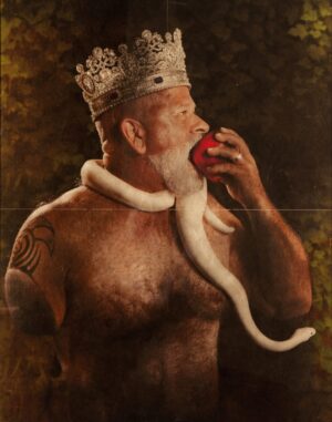 A man with a beard and a crown eating an apple.