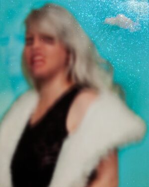 A blurry picture of a woman in a white fur coat.