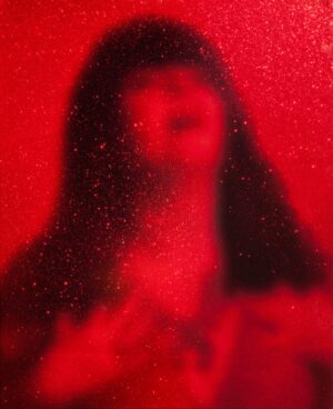 A blurry image of a woman in red.