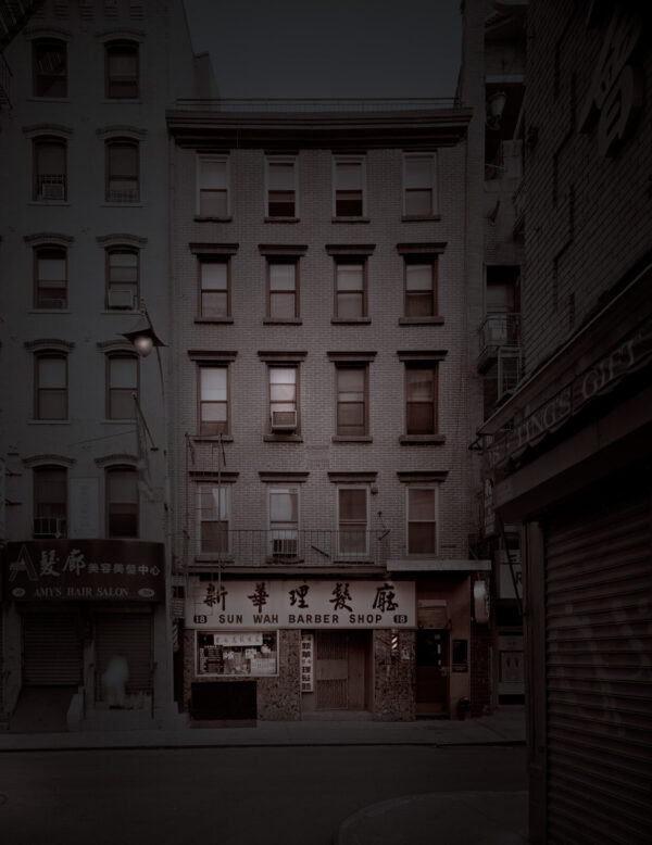 A dark city street with buildings and signs.