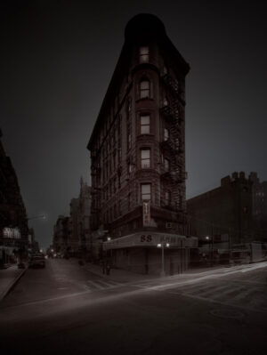 A dark city street with buildings and cars.