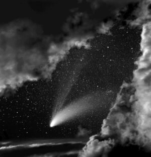 A black and white photo of a comet in the night sky.