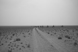 A black and white photo of some people on horseback.