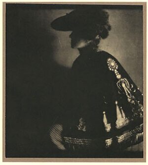 A woman in black and white standing next to a wall.