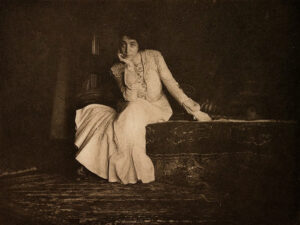 A woman sitting on top of a wooden box.