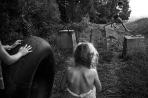 A child in the woods with an object on his back.