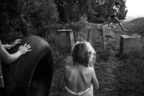A child in the woods with an object on his back.