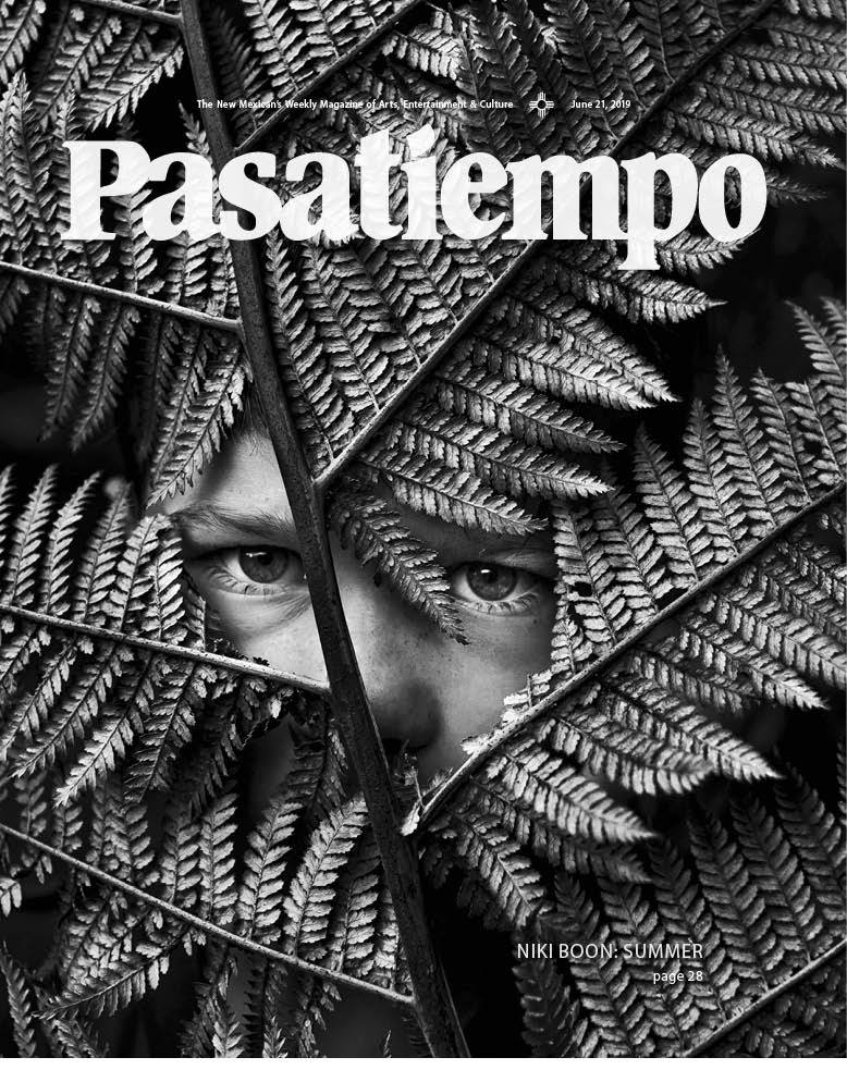 Child's face partially obscured by ferns.