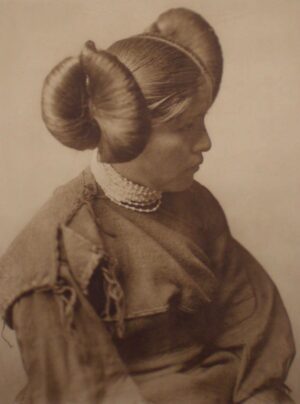 A woman with long hair and a large bun.
