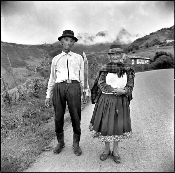 A man and woman standing on the side of a road.