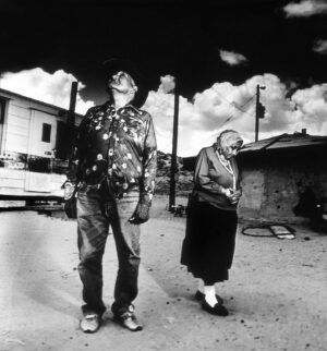 A man and woman standing under an umbrella.
