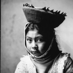 A young girl wearing a hat with a fish on it.