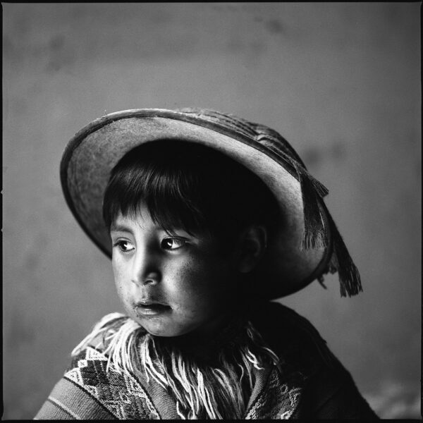 A young girl wearing a hat and looking at the camera.