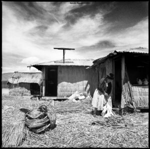A woman standing in front of a shack.
