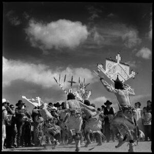 A group of people in costume dancing on the beach.