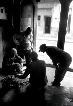 A group of men standing around in front of a window.
