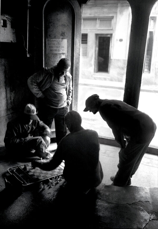 A group of men standing around in front of a window.