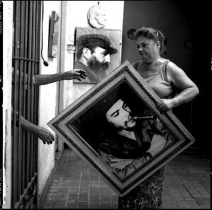 A woman holding up an old picture of herself.
