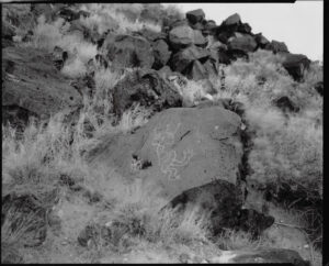 A black and white photo of rocks on the side of a hill.