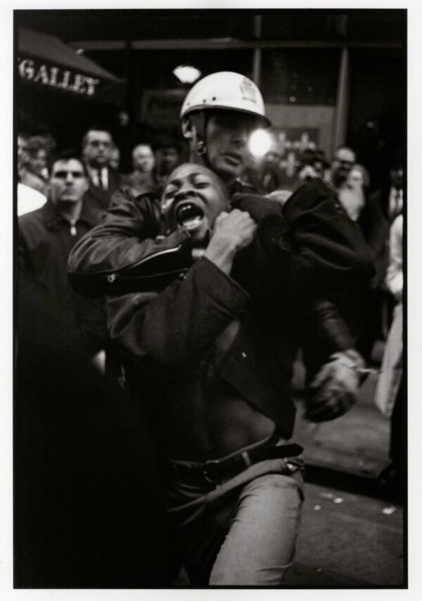 A man in a helmet is being held up by another man.