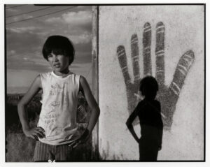 Two young boys standing in front of a mural.