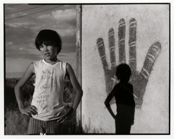 Two young boys standing in front of a mural.