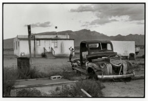 A man standing next to an old truck.