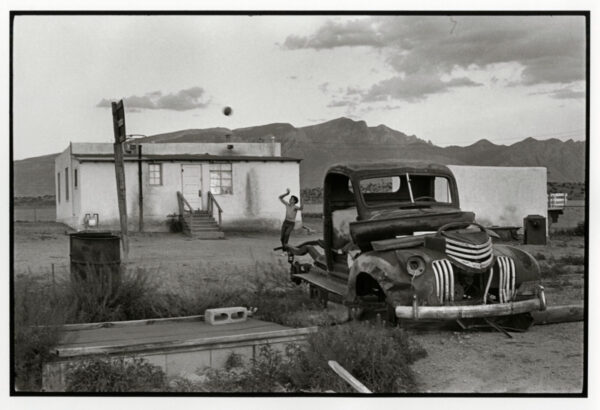 A man standing next to an old truck.