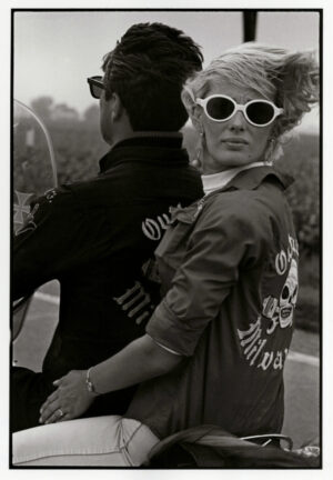 A woman in sunglasses holding onto another person.