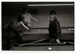 A man and woman playing pool in an indoor setting.