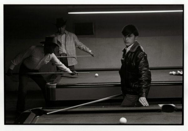 A man and woman playing pool in an indoor setting.