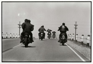 A group of people riding motorcycles on the road.