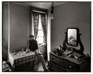 A man sitting at the table in front of a mirror.