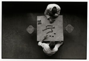 Two men sitting at a table with letters on it.