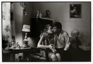 A man and woman sitting on the couch with another person.