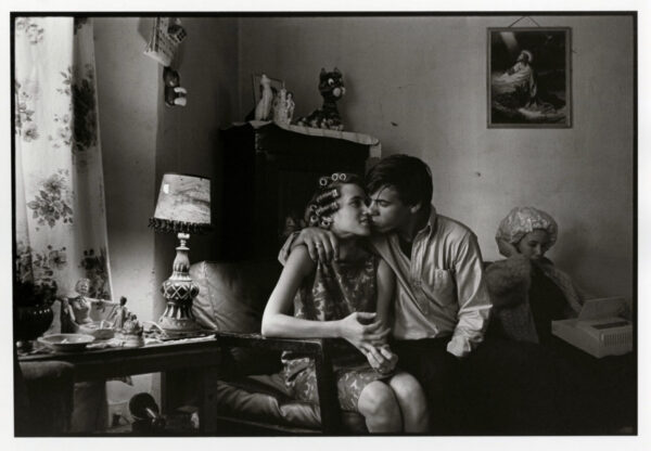 A man and woman sitting on the couch with another person.