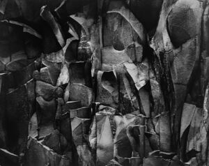 A black and white photo of a wall made out of rocks.