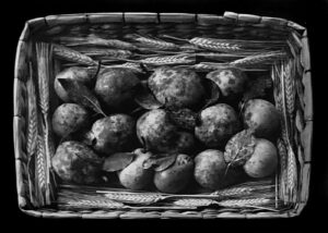 A basket full of apples sitting on top of the ground.